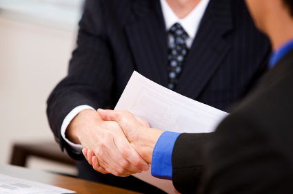 Businesspeople shaking hands with paper